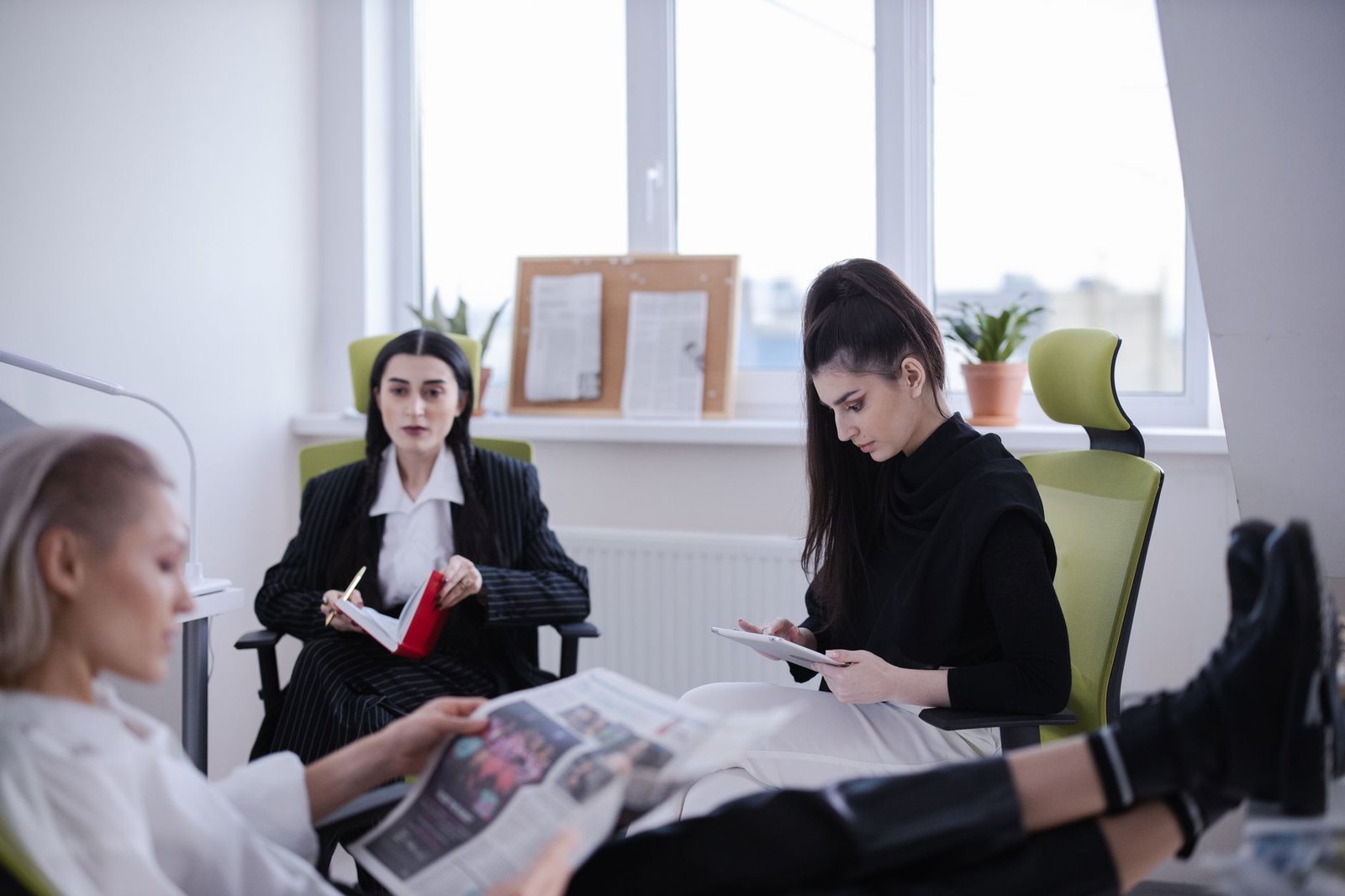 Three women in a modern office setting reading and working together indoors. — Best Non GamStop Casino UK Reviews and Ranking