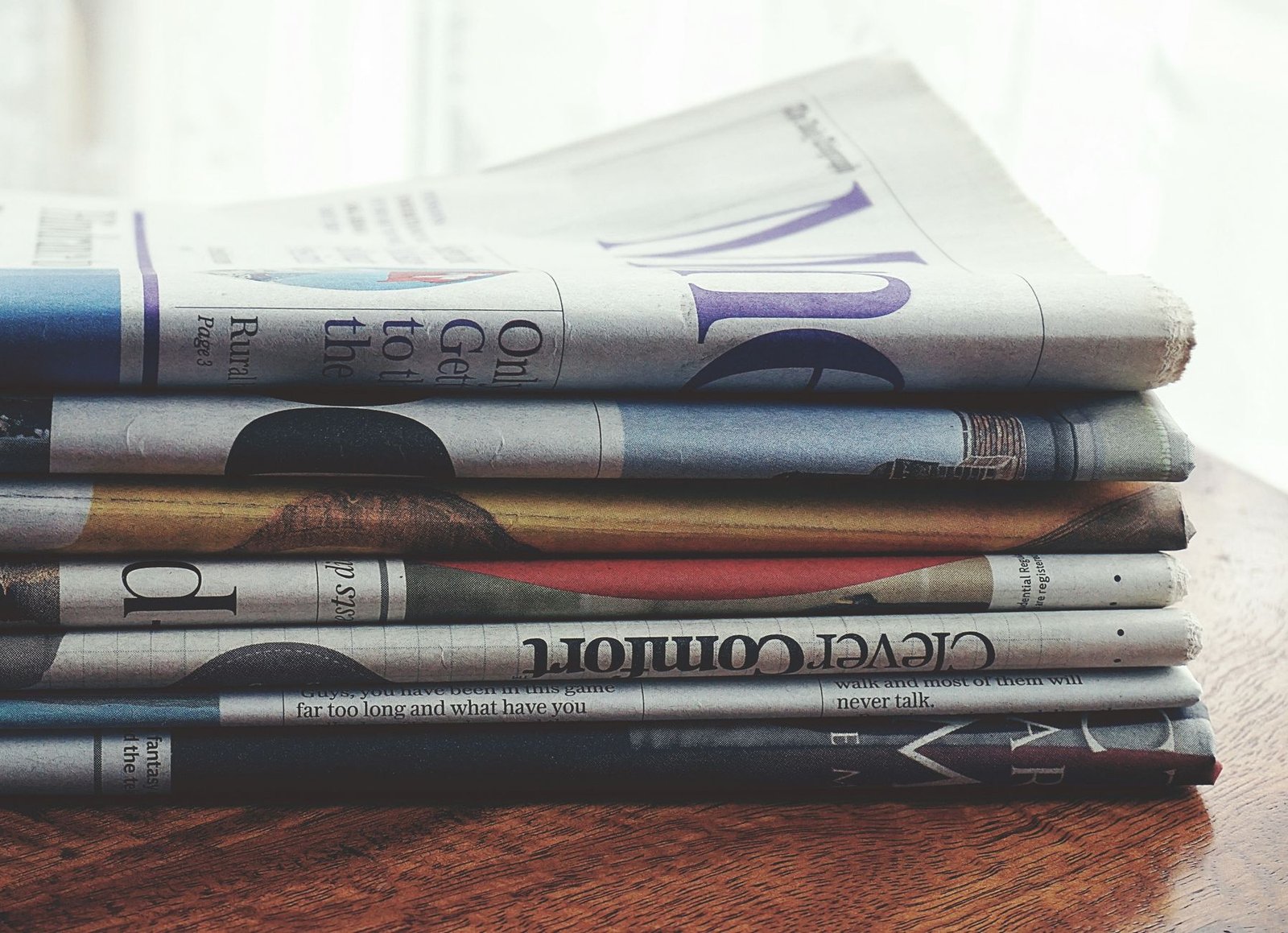 A stack of folded newspapers placed on a wooden table, symbolizing news and information. — Best Non GamStop Casino UK Reviews