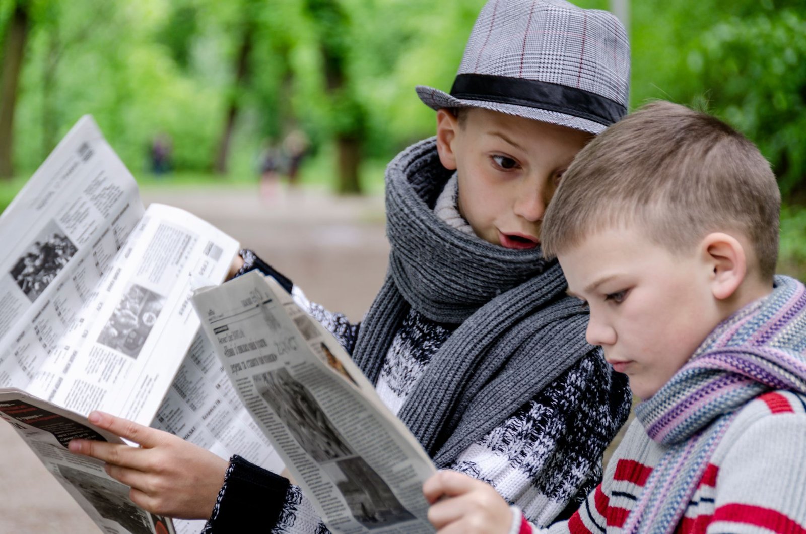 Two young boys reading newspapers together in a lush green park in Lviv, Ukraine. — Best Non GamStop Casino UK Reviews and Ra