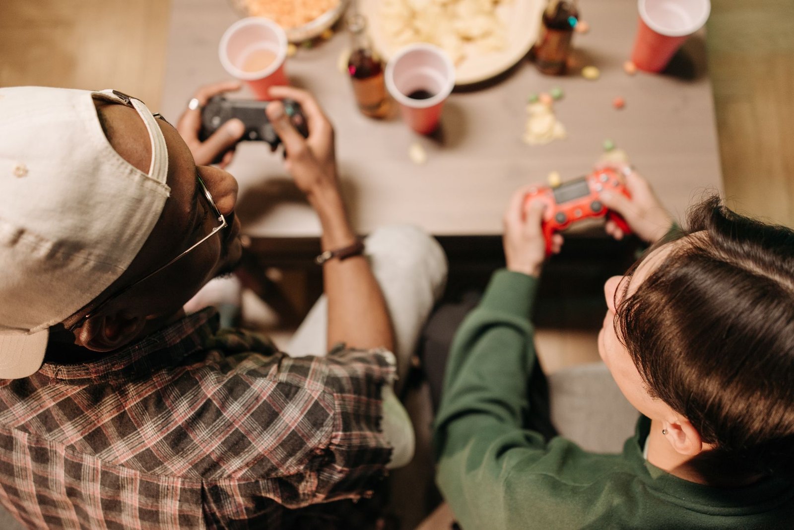 Two friends playing video games with controllers, sharing a fun indoor experience. — Experience Real-Time Casino Play Anytime