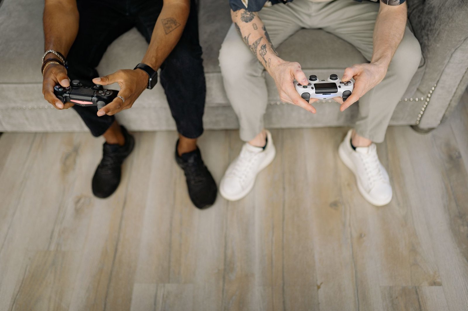 Two friends with gaming controllers focusing on a video game indoors from above. — MPO1221 Online Slot Tournaments With Excit